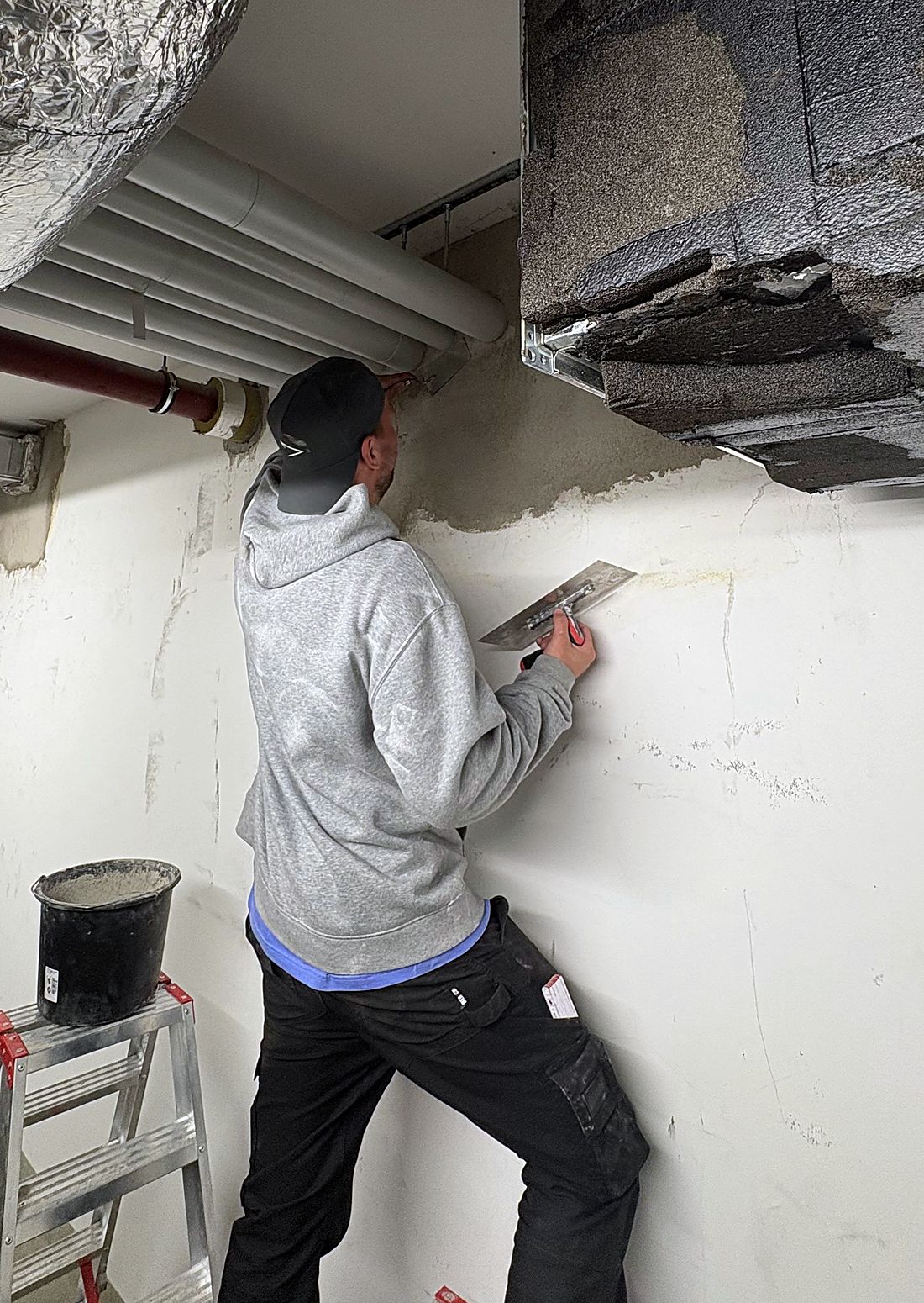 Monteur der CoJa-Infratech beim Verarbeiten von Brandschutzmörtel an einem Bauteilanschluss